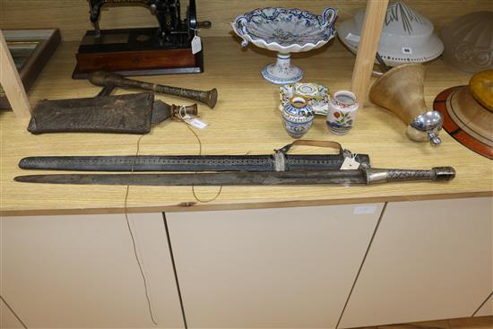 A Songye style ceremonial axe, the wooden handle covered in snakeskin, a Ngala style tribal knife and an Indian long sword,